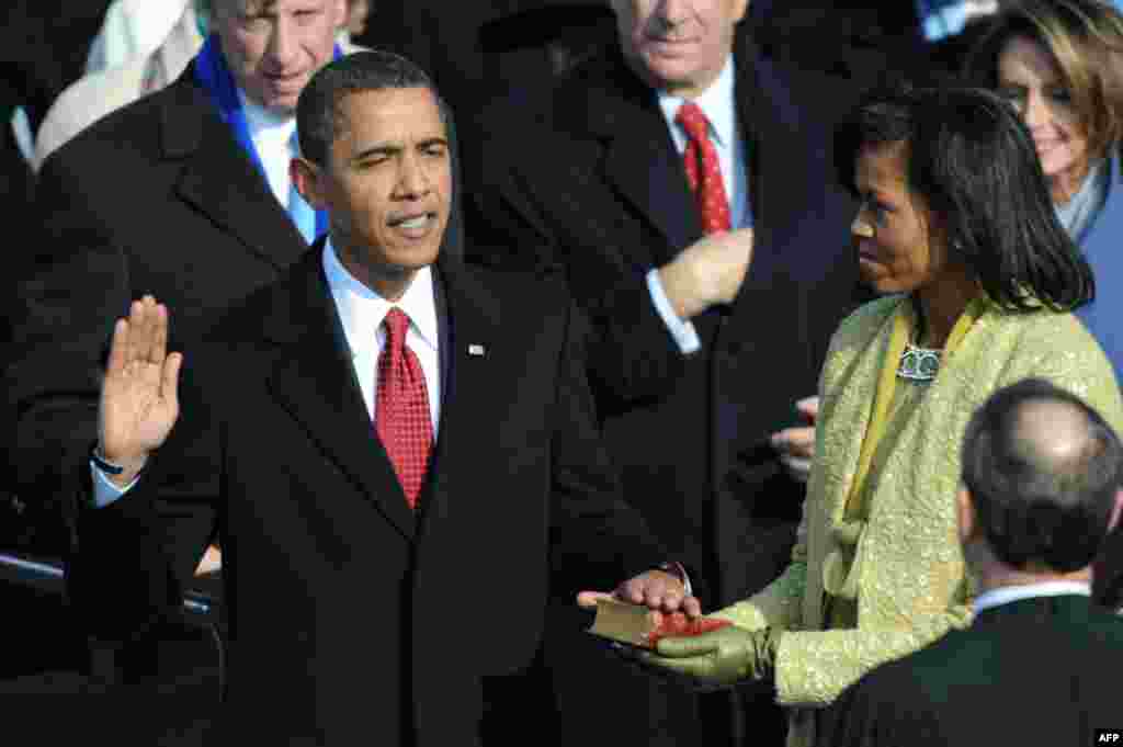 Barack Obama is sworn in as 44th US president by Chief Justice John Roberts beside wife Michelle on January 20, 2009 at the Capitol in Washington, DC.
