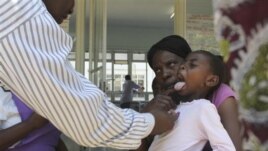 A doctor examins a child suffering from typhoid at a local infectious disease hospital in Harare, Tuesday, Nov.15, 2011. Health authorities say 207 cases of typhoid, spread by contaminated water and food, are being treated in Zimbabwe's capital after a pr
