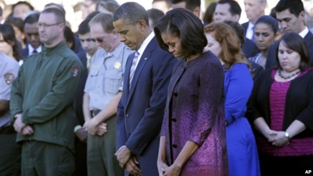 President Barack Obama, first lady Michelle Obama, and members of the White House staff observe a moment of silence to mark the 11th anniversary of the September 11, 2001 terrorist attacks on the South Lawn of the White House.