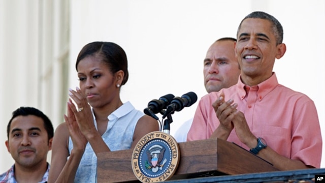President Barack Obama and first lady Michelle Obama applaud during a Fourth of July celebration on the South Lawn of the White House, July 4, 2013. 
