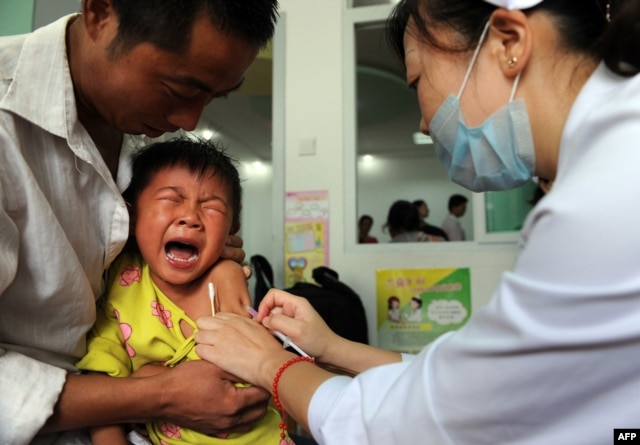 FILE - A Chinese boy screams out in pain as he gets inoculated against measles as part of a free 10-day nationwide campaign to urge parents to participate amid public fears about the safety of the inoculations in Hefei, in eastern China's Anhui province on Sept. 11, 2010.