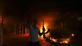 Wani dan zanga-zanga a kofar karamin ofishin jakadancin Amurka dake cin wuta a Benghazi a kasar Libya