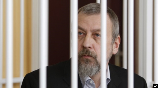 Former presidential candidate Andrei Sannikov sits in a cage during a court hearing in Minsk April 27, 2011.