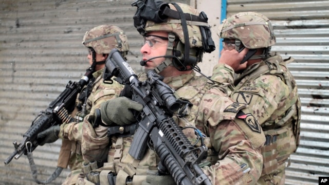 U.S. soldiers stand guard at the scene of a suicide attack in Kabul, Afghanistan, Feb. 27, 2013.