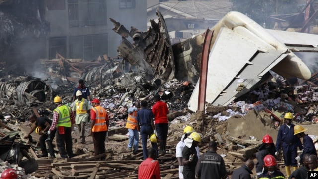 Rescue workers gather at the site of a plane crash in Lagos, Nigeria, June 4, 2012.
