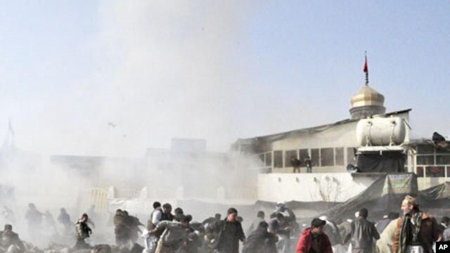 People react seconds after a suicide blast targeting a Shi'ite Muslim gathering in Kabul, December 6, 2011.