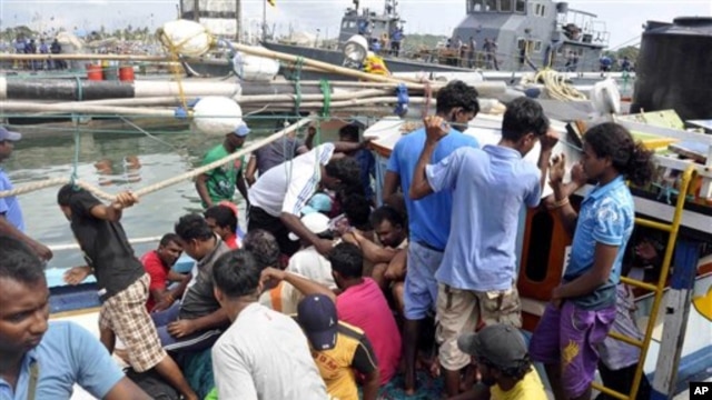 Foto yang dirilis tanggal 17 Oktober 2012 ini memperlihatkan para pencari suaka dari Sri Lanka tengah berupaya keluar dari kapal nelayan yang mereka tumpangi setelah tertangkap di sekata pangkalan angkatan laut di Galle, Sri Lanka. (AP Photo/Sajeewa Wijeweera). Sebuah kapal yang mengangkut 22 pencari suaka asal Sri Lanka, dilaporkan terdampar di dekat pulau Nusakambangan, Selasa (29/1).