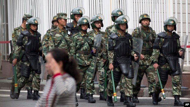 Cảnh sát bán quân sự Trung Quốc trang bị với lá chắn và dùi cui tuần tra gần Quảng trường Nhân dân ở Urumqi, ngày 23/5/2014.
