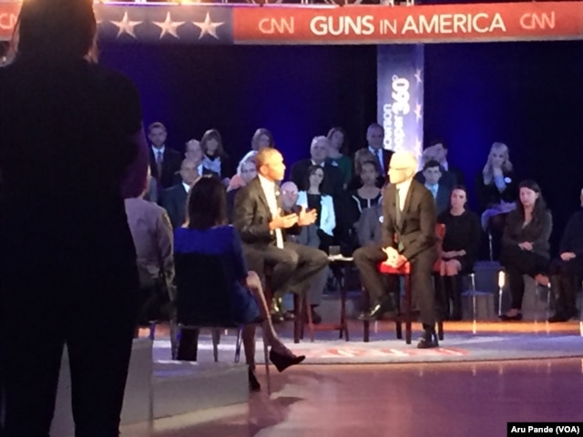 President Barack Obama, left, speaks during a CNN televised town hall meeting hosted by Anderson Cooper, right, at George Mason University in Fairfax, Va., Jan. 7, 2016.