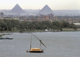 n this file photo of January 22, 2013, a traditional felucca sailing boat carries a cargo of hay as it transits the Nile river passing the Pyramids of Giza in Cairo, Egypt.