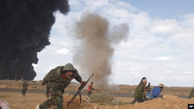 Rebels run for cover during clashes with pro-Gaddafi forces between Ras Lanuf and Ben Jawad, March 9, 2011