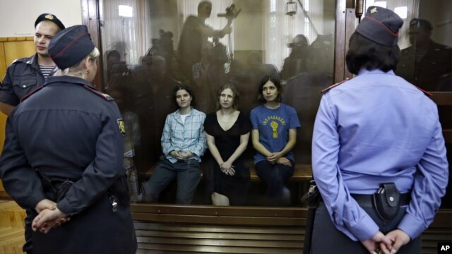Feminist punk group Pussy Riot members, from left, Yekaterina Samutsevich, Maria Alekhina and Nadezhda Tolokonnikova sit in a glass cage at a courtroom in Moscow, Russia, Aug 17, 2012.