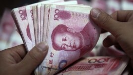 A bank clerk counts Chinese banknotes at a branch of Industrial and Commercial Bank of China in Huaibei, Anhui province, June 8, 2012. 