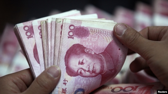Sebuah pegawai bank menghitung uang kertas Tiongkok di cabang Bank Industri dan Komersial di Huaibei, propinsi Anhui, Tiongkok (Foto: dok). Tiongkok telah mengeluarkan data statistik terkait kesenjangan pendapatan di negara tersebut setelah merahasiakan data tersebut sejak tahun 2000, Jum'at (18/1).