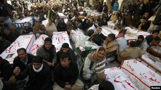 Người Hồi giáo Shia ngồi cạnh quan tài của các nạn nhân vụ đánh bom kép hôm thứ Năm tại Quetta, 12/1/2013