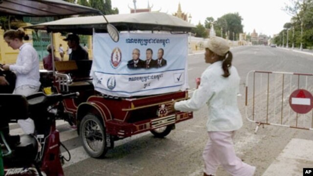 An election campaign poster of Prime Minister Hun Sen's ruling Cambodian People's Party hangs on the back of a motorized rickshaw parked at a blocked street in front of the Royal Palace in Phnom Penh.