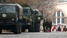 Armed personnel and military trucks without markings are seen near a checkpoint on territory controlled by the self-proclaimed Donetsk People's Republic in Donetsk, eastern Ukraine, Nov. 12, 2014.