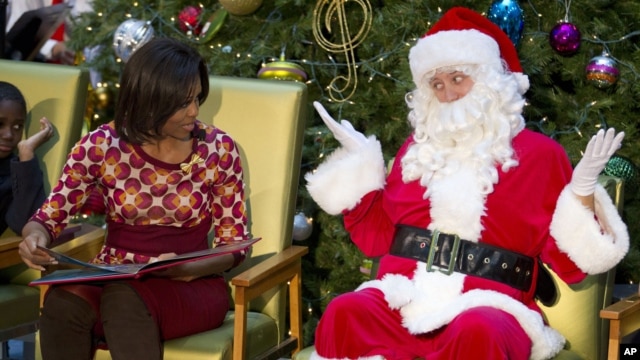 Santa Claus gestures toward first lady Michelle Obama, at Children's National Medical Center  in Washington