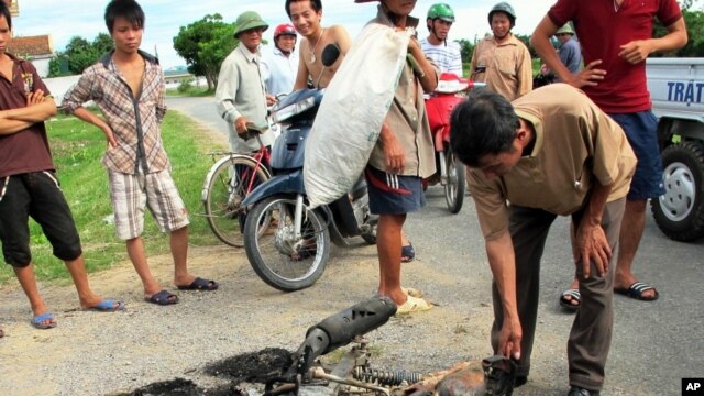 Cư dân vây quanh một chiếc xe máy bị cháy thành than trong tỉnh Nghệ An. Dân làng phẫn nộ vì bị trộm chó đã thu giữ xe máy của các tên trộm chó và nổi lửa đốt xe.