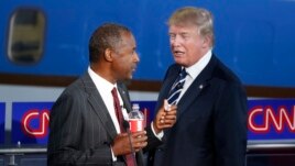 Republican U.S. presidential candidates Dr. Ben Carson and businessman Donald Trump talk during a commercial break in the Republican presidential candidates debate, Sept. 16, 2015.