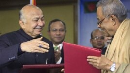 Indian Home Minister Sushilkumar Shinde, left, and his Bangladeshi counterpart Mohiuddin Khan Alamgir prepare to shake hands after signing agreements in Dhaka, Bangladesh, Jan. 28, 2013