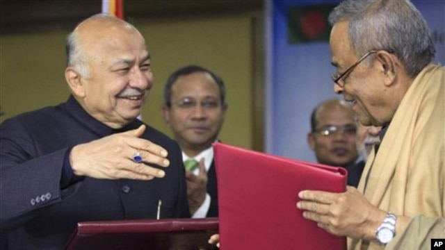 Indian Home Minister Sushilkumar Shinde, left, and his Bangladeshi counterpart Mohiuddin Khan Alamgir prepare to shake hands after signing agreements in Dhaka, Bangladesh, Jan. 28, 2013