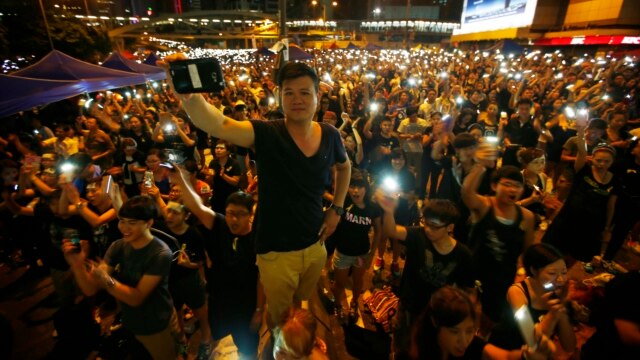 Protesters turn on their mobile phone flashlights as they block an area outside the government headquarters building in Hong Kong Oct. 1, 2014. 