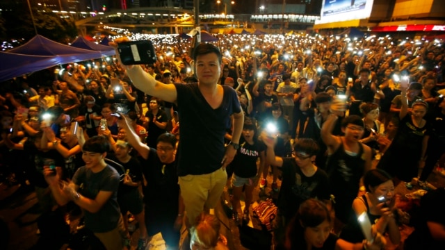 Protesters turn on their mobile phone flashlights as they block an area outside the government headquarters building in Hong Kong Oct. 1, 2014.