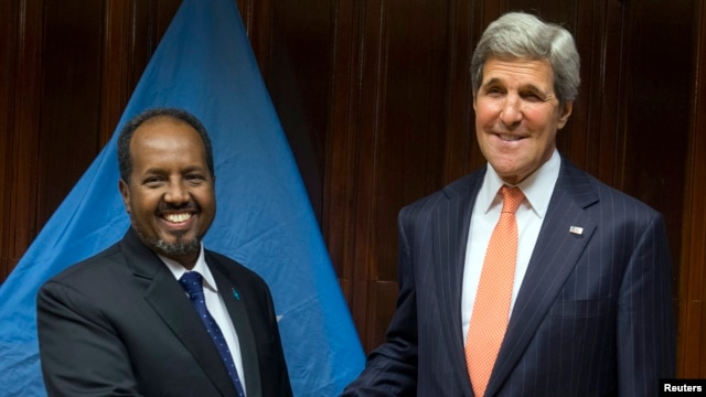 U.S. Secretary of State John Kerry (R) and Somalia's President Hassan Sheikh Mohamud shake hands before a meeting at Addis Ababa.