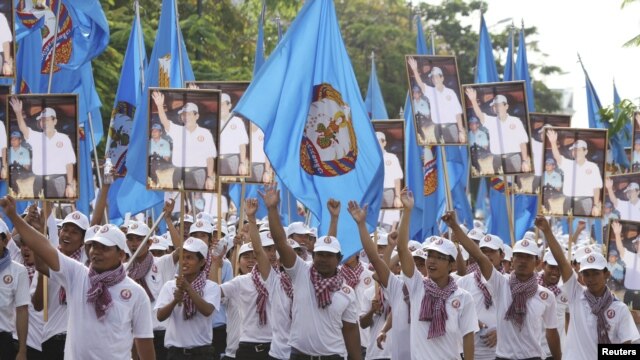 Supporters of the ruling Cambodian Peoples Party (CPP) march with party flags, posters