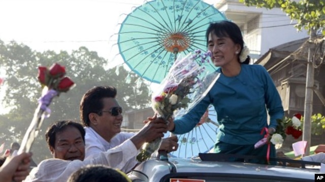Pro-democracy leader Aung San Suu Kyi receives flowers from supporters on her vehicle during her election campaign trip to Thone-Gwa township in Rangoon, Burma, February 26, 2012.