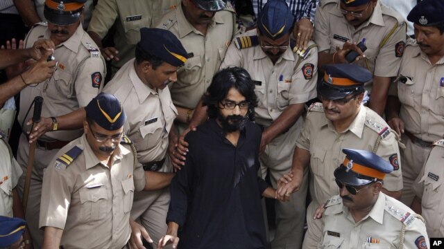 Indian policemen escort political cartoonist Aseem Trivedi, center in black as they leave a court in Mumbai, India, Monday, Sept. 10, 2012.