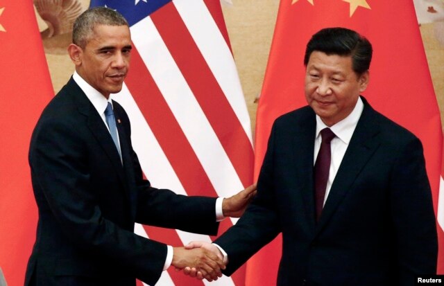 U.S. President Barack Obama shakes hands with China's President Xi Jinping in front of U.S. and Chinese national flags during a joint news conference at the Great Hall of the People in Beijing, Nov. 12, 2014.