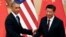 FILE - U.S. President Barack Obama (L) shakes hands with China's President Xi Jinping in front of U.S. and Chinese national flags during a joint news conference at the Great Hall of the People in Beijing, Nov. 12, 2014.