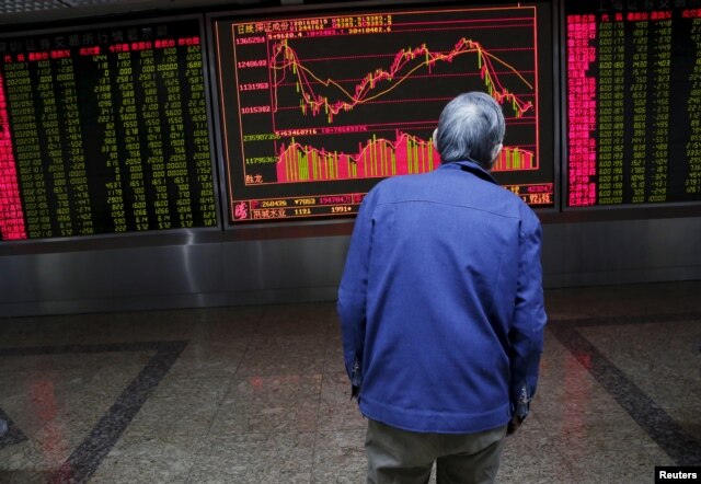 An investor watches an electronic board showing stock information on the first trading day after the week-long Lunar New Year holiday at a brokerage house in Beijing, China, Feb. 15, 2016.