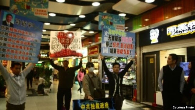 黄文勋、张圣雨等人在广州体育中心西地铁站去天河城处举牌抗议(博讯图片/网友提供)