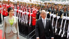 Burma President Thein Sein (R) and Thai Prime Minister Yingluck Shinawatra (L) review the honor guard during a welcoming ceremony in Bangkok, July 23, 2012.