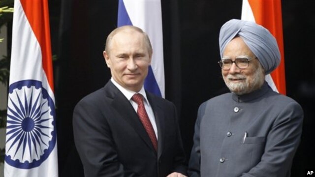 Presiden Rusia Vladimir Putin (kiri) disambut PM India Manmohan Singh di kediamannya di New Delhi, India (24/12). 
