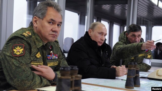 Владимир Путин и министр обороны России Сергей Шойгу (слева) 