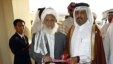 Qatari Assistant Minister for Foreign Affairs Ali bin Fahd al-Hajri (r) and Jan Mohammad Madani, (l) one of the Taliban officials cut the ribbon at the official opening ceremony of a Taliban office in Doha, Qatar,  June 18, 2013. 