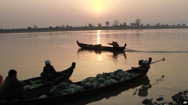 Grocery vendors sit on their boats to cross Irrawaddy river in Myitkyina, February 25, 2012, in Myitkyina, Kachin State, northern Burma.