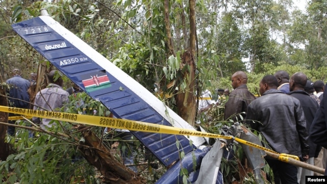 People gather at the scene where a police helicopter crashed at a forest in the Kibiko area of Ngong township, on the outskirts Nairobi, June 10, 2012. 