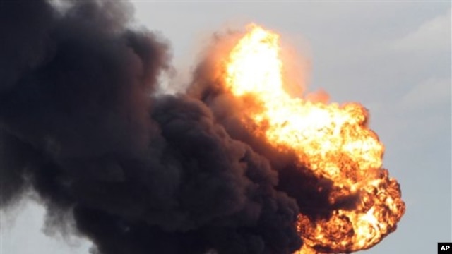 A fuel storage depot, burns after being struck during fighting between rebels and pro-Moammar Gadhafi forces, in Sedra, eastern Libya, March 9, 2011.