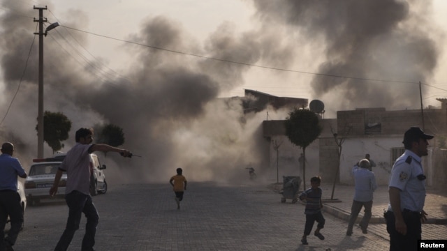 Smoke rises over the streets after an mortar bomb landed from Syria in the border village of Akcakale, southeastern Sanliurfa province, October 3, 2012.