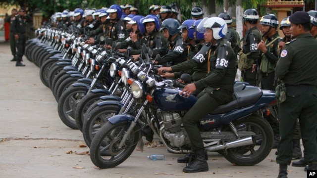 Cambodian military police officers stand by with their motorcycles at Stung Meanchey where Prime Minister Hun Sen made his first public appearance since Sunday's election, in Phnom Penh, July 31, 2013.