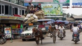 Vehicles make their way on a road near local bazaar in Mawlamyine, Mon State, Burma, March 11, 2011.
