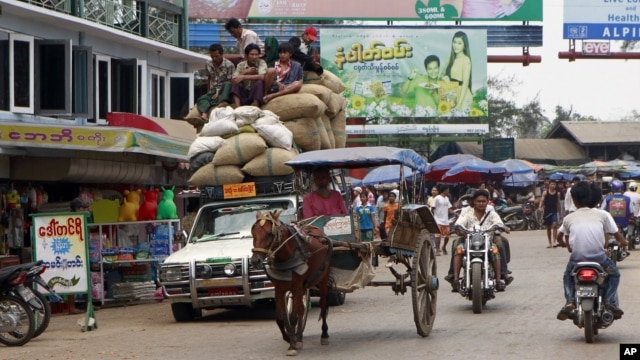 Vehicles make their way on a road near local bazaar in Mawlamyine, Mon State, Burma, March 11, 2011.