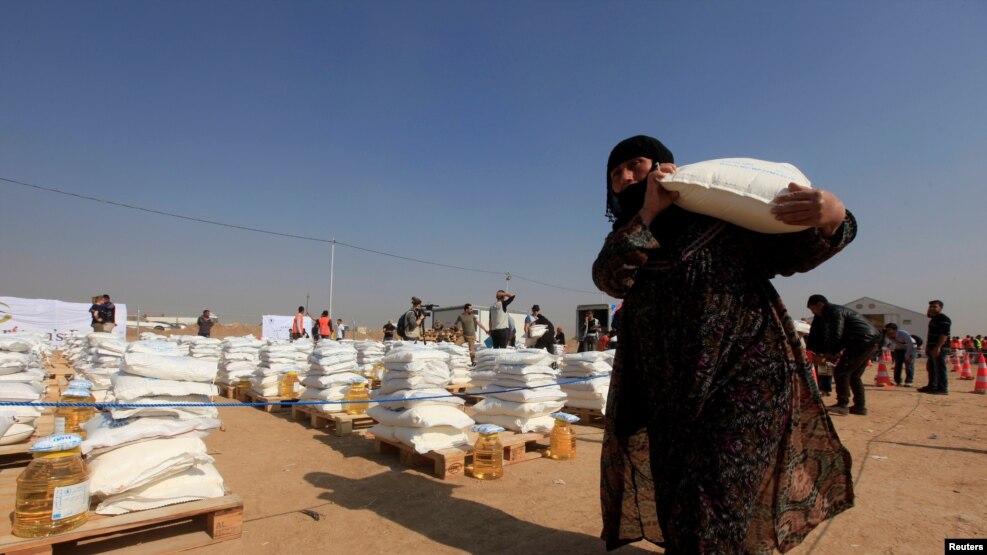 Una desplazada de Mosul carga alimentos en el campo de refugiados de Khazer, al este de Mosul. Noviembre 7 de 2016.