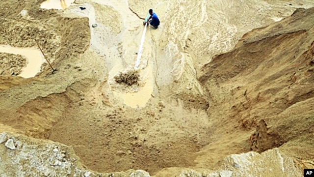 A worker waters the site of a rare earth metals mine at Nancheng county, Jiangxi province, China 29 Dec 2010