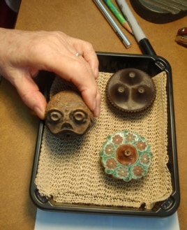 Ceramic opium pipe bowls; the center one has a toad design.(VOA/T. Banse)